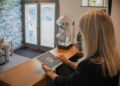 Woman using a tablet at a reception desk.