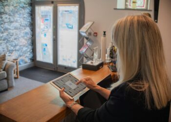 Woman using a tablet at a reception desk.